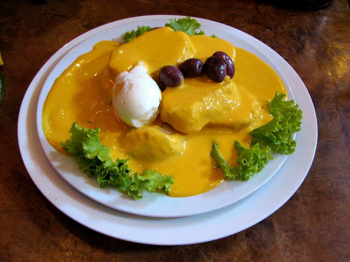 Papa a la huancaína con salsa amarilla, huevo y aceituna